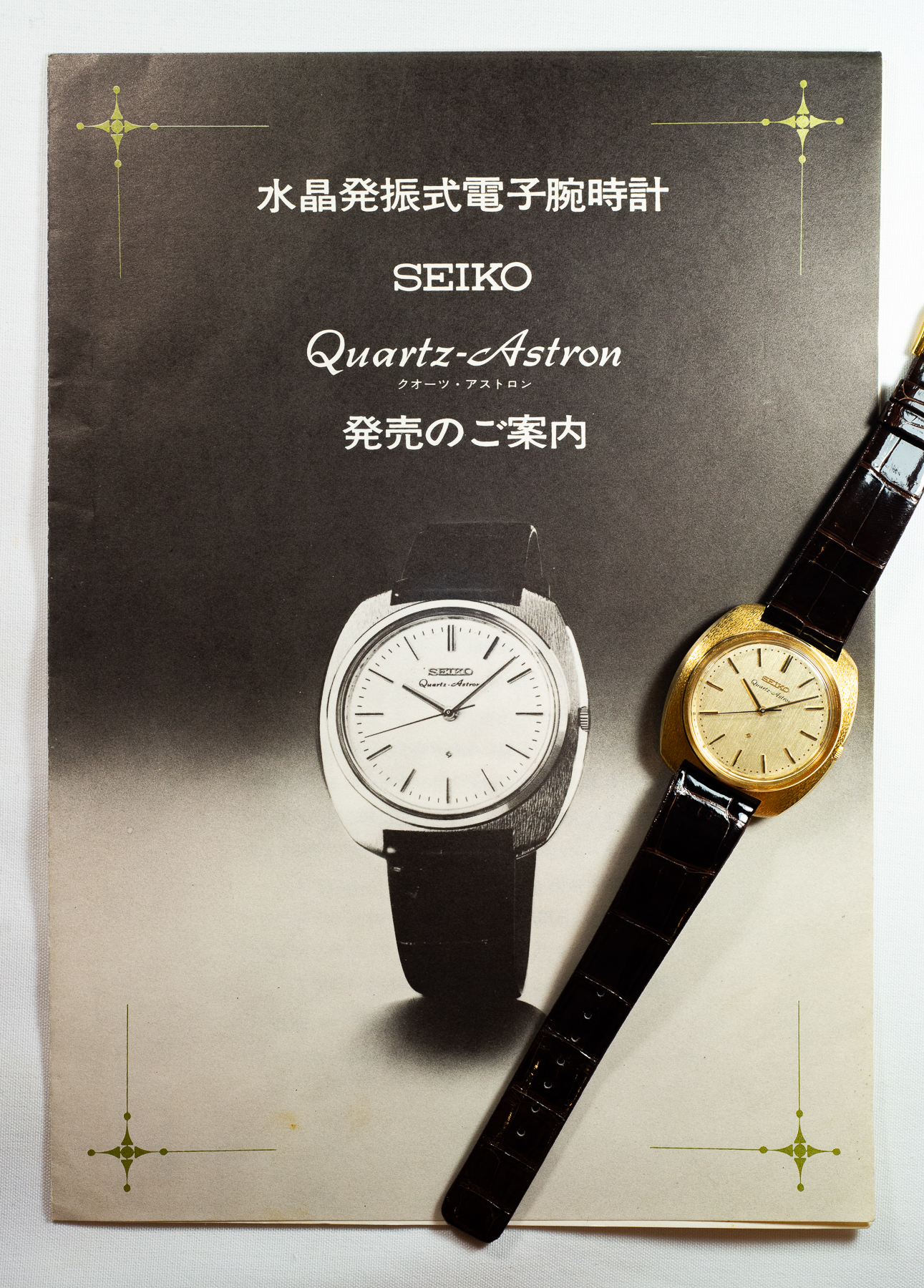 An early Seiko Quartz-Astron advertisement beside a gold wristwatch.